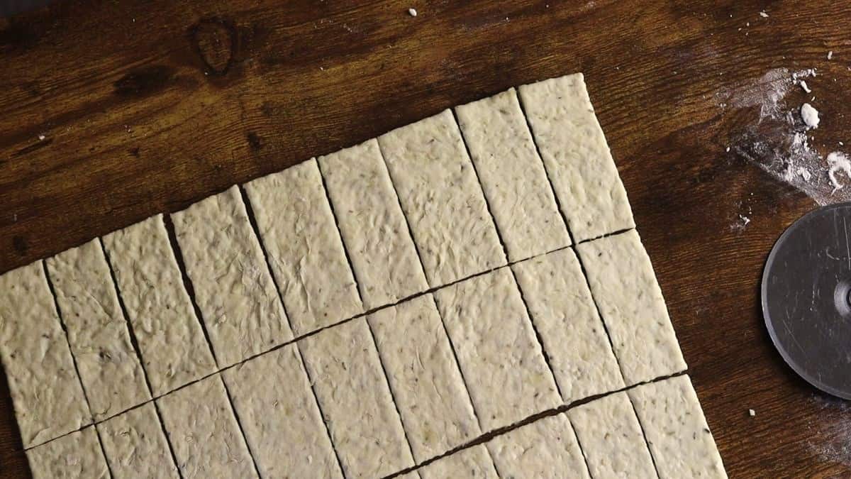 Dough cut into rectangular shapes on a wooden surface.