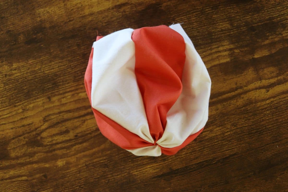 White and orange fabric panels sewn together to form a bowl shape.
