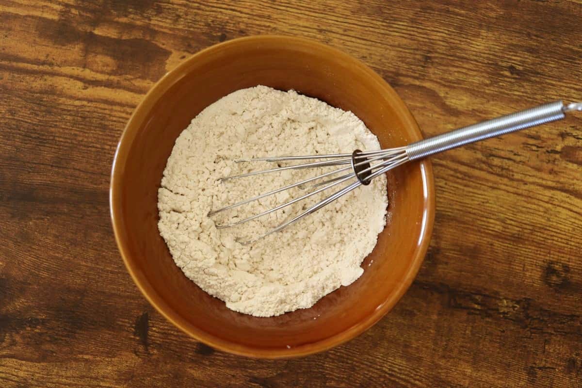 Flour mixture in a bowl with a whisk sitting in it.