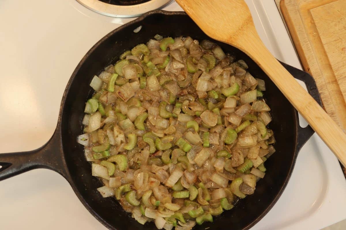 Celery and onions cooked in a reduced broth in a cast iron skillet.
