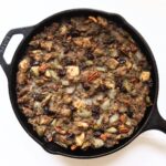 Turkey dressing with sausage, pecans, dried cherries, and celery baked in a cast iron skillet.