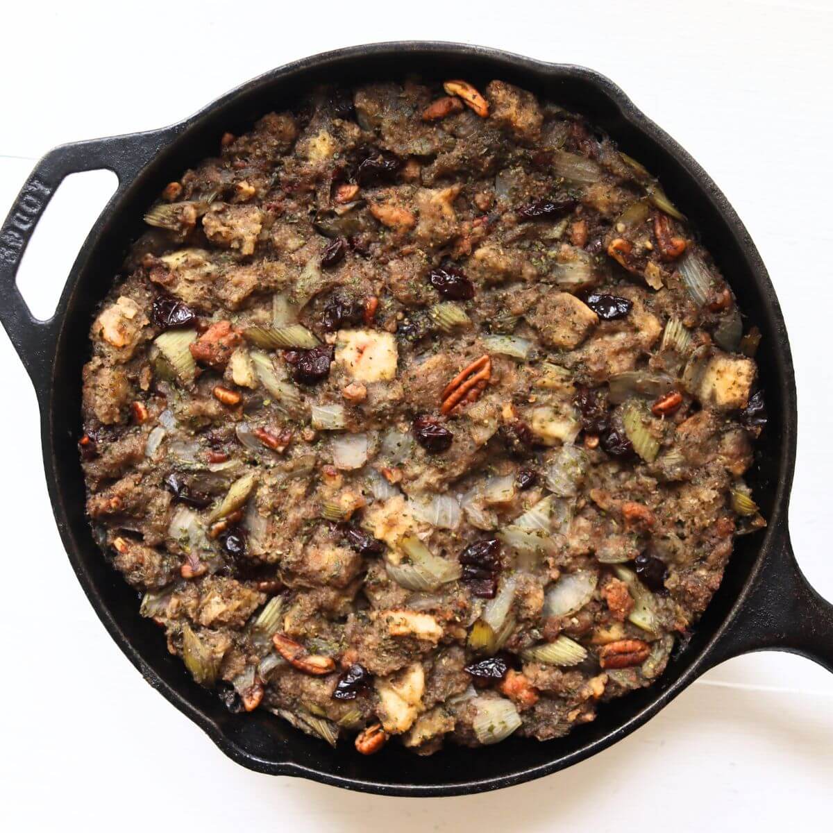 Turkey dressing with sausage, pecans, dried cherries, and celery baked in a cast iron skillet.