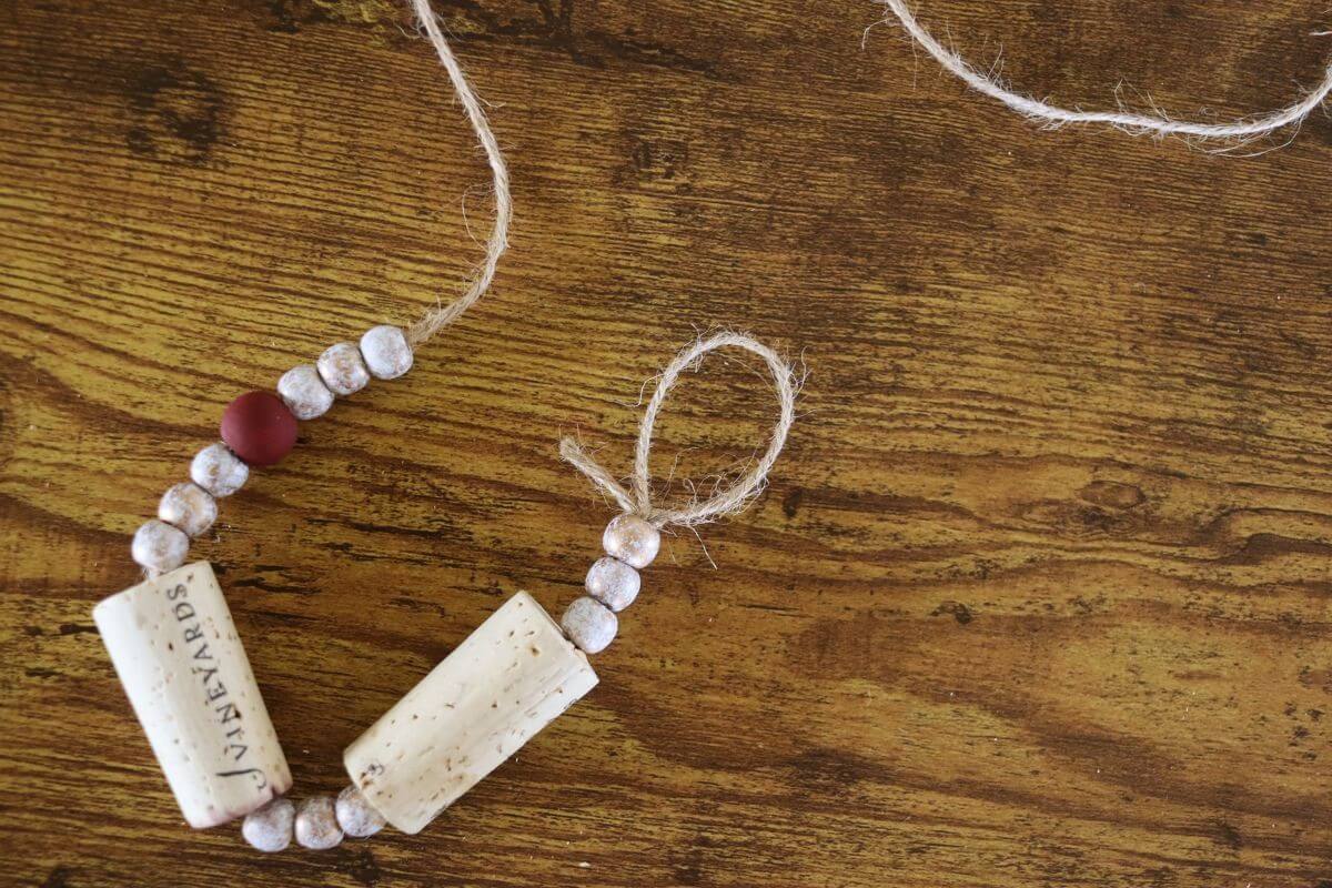 A strand of beads and wine corks on jute twine with a loop tied in the end of it.