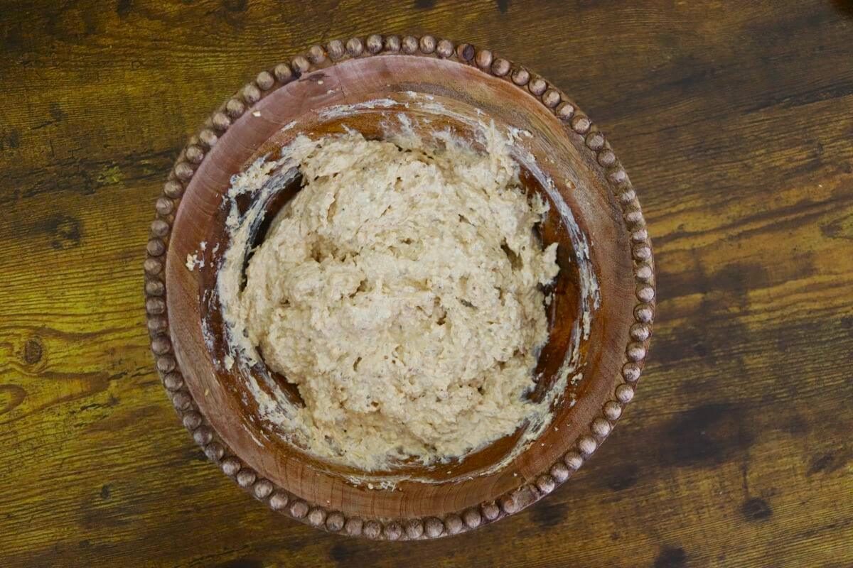 Creamy dip with a very light orange tint in a wooden bowl.