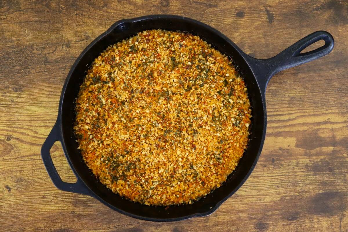 A cast iron skillet with a golden orange crusty mixture in it.