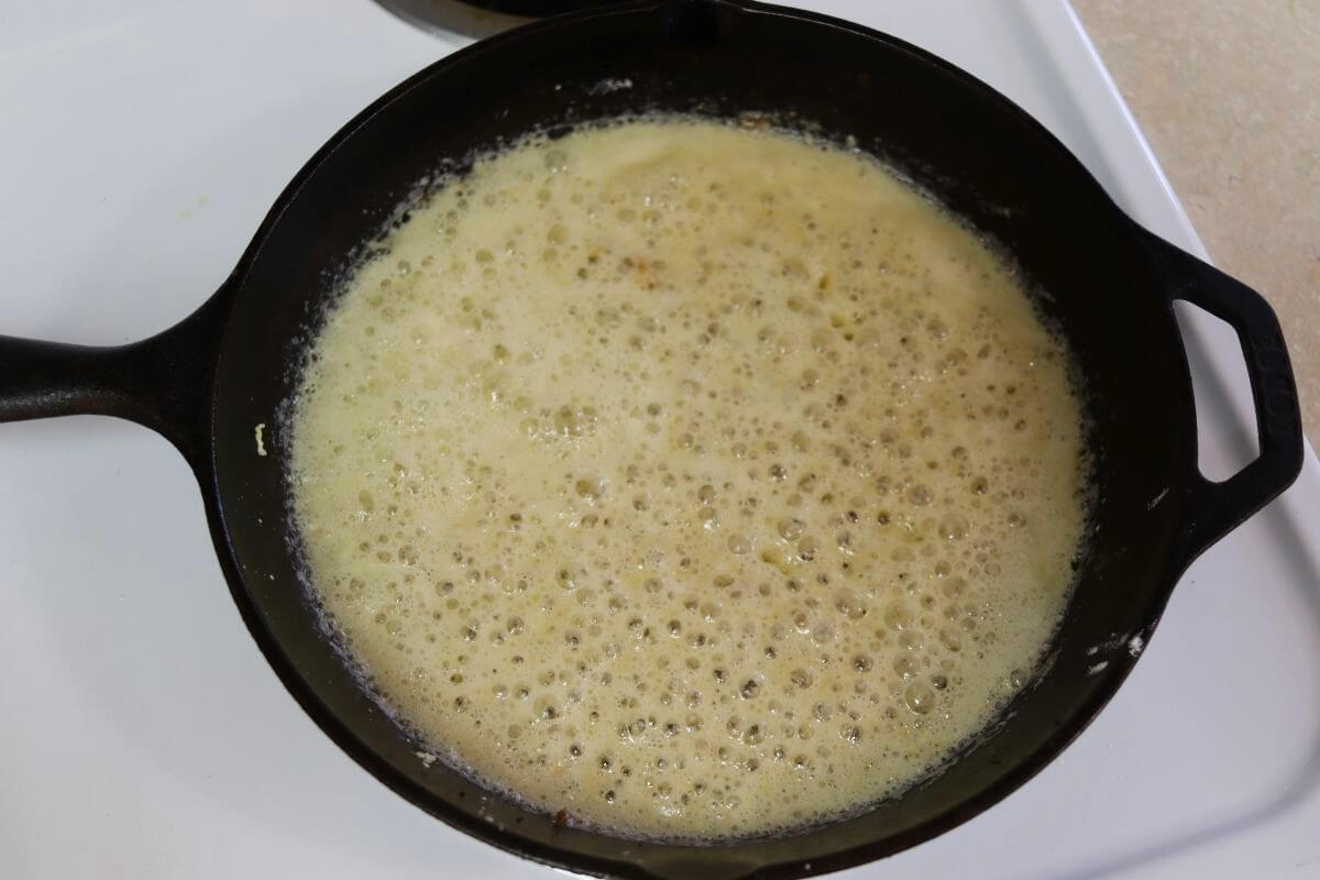 A roux simmering in a cast iron skillet. 