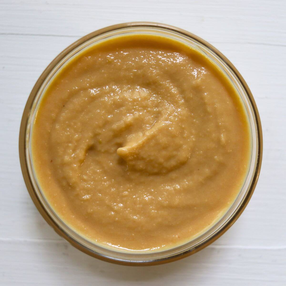 Homemade Dijon mustard with a thick, creamy texture in a glass bowl.