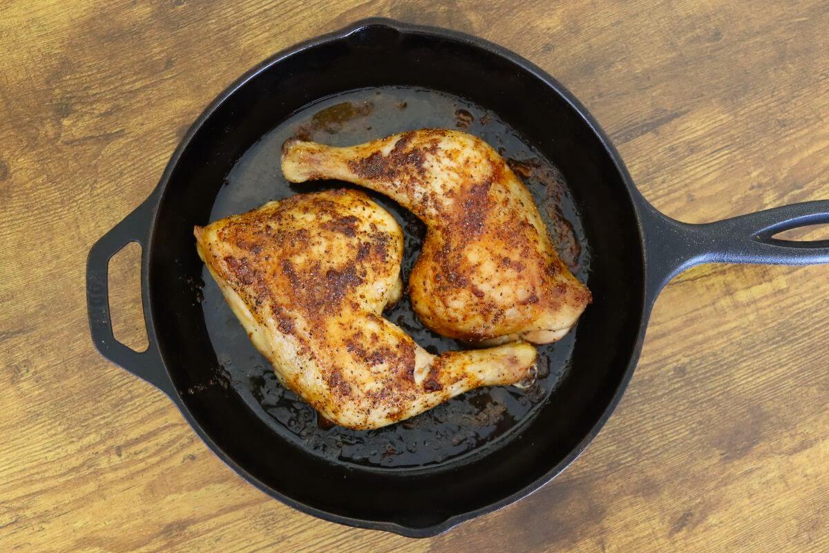 Skillet-baked chicken leg quarters with crisp, seasoned skin.