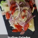 Iceberg wedge salad with chopped meats, provolone, onion, tomatoes, dressing, and “Italian Grinder No Roll Needed” text.