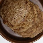 Fennel sausage patties in a brown bowl with Homemade Fennel Sausage Recipe text overlay.