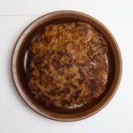 Homemade hot Italian sausage patties stacked in a brown bowl.
