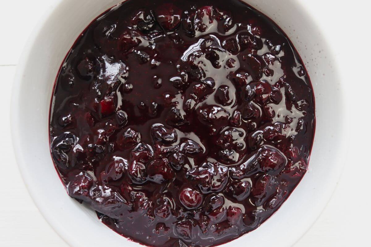White bowl filled with blueberry compote.