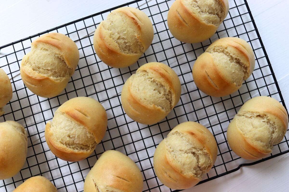 Freshly baked dinner rolls arranged on a cooling rack.
