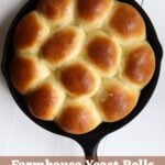 Cast iron skillet filled with homemade yeast rolls. Text overlay reads "Farmhouse Yeast Rolls (from scratch)".