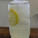 Glass of fresh squeezed lemonade with ice and a lemon slice. Text reads "Fresh Squeezed Lemonade".