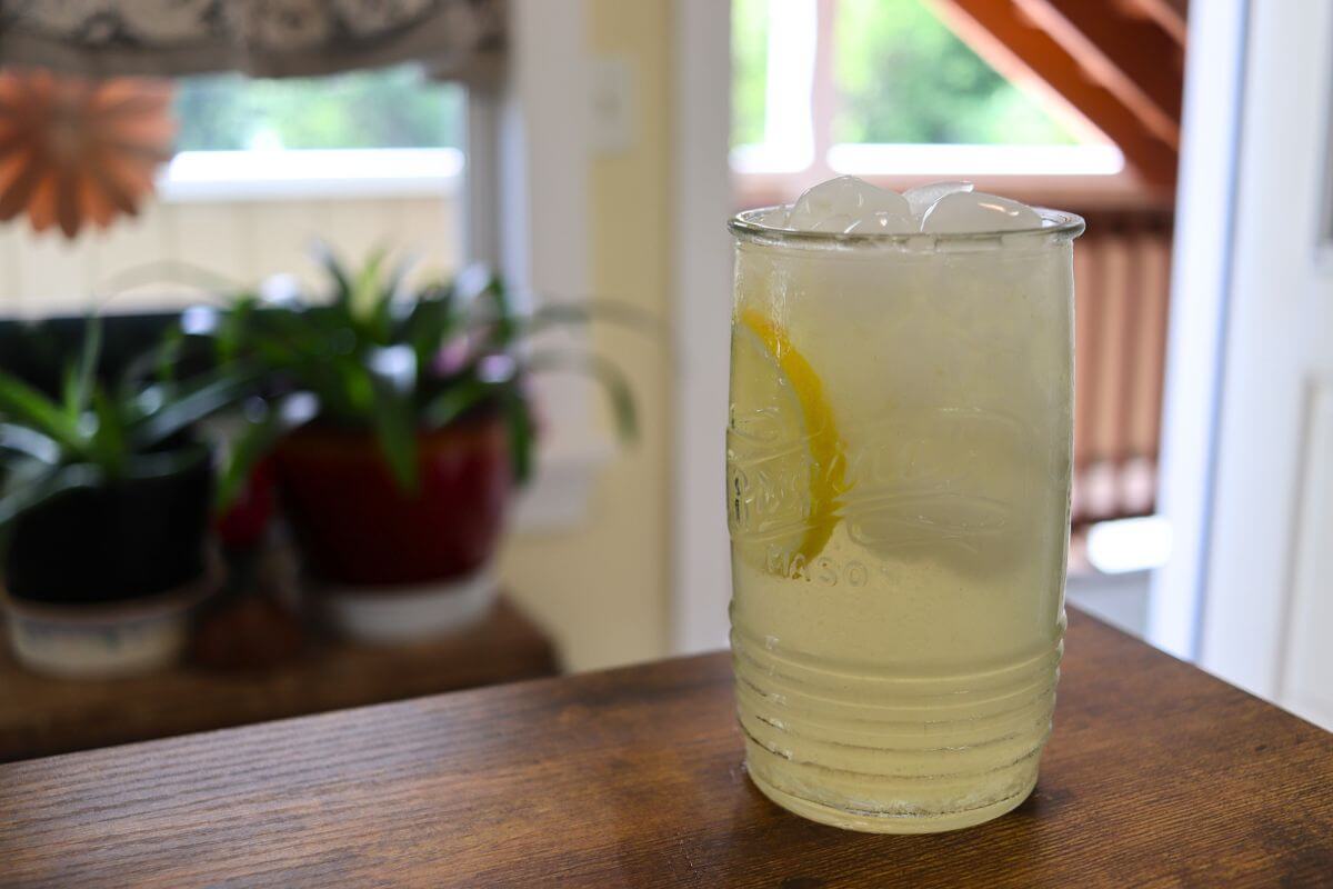 Mason jar-style glass filled with fresh squeezed lemonade, ice, and a lemon slice.