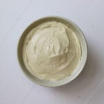 Bowl of whipped cream cheese spread with smooth swirls on the surface.
