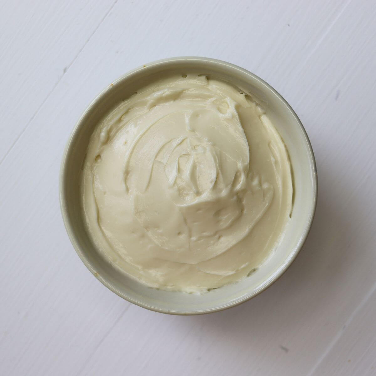 Bowl of whipped cream cheese spread with smooth swirls on the surface.