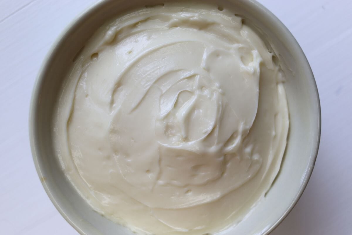 White bowl filled with creamy whipped spread on a white background.