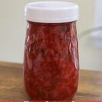 Jar filled with red jam and text overlay reading Small Batch Strawberry Jalapeño Refrigerator Jam.