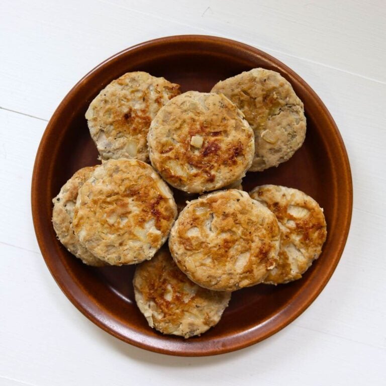 Homemade apple pork sausage patties served on a brown plate.