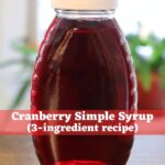 Homemade cranberry simple syrup in a glass bottle with the text "Cranberry Simple Syrup (3-ingredient recipe)".