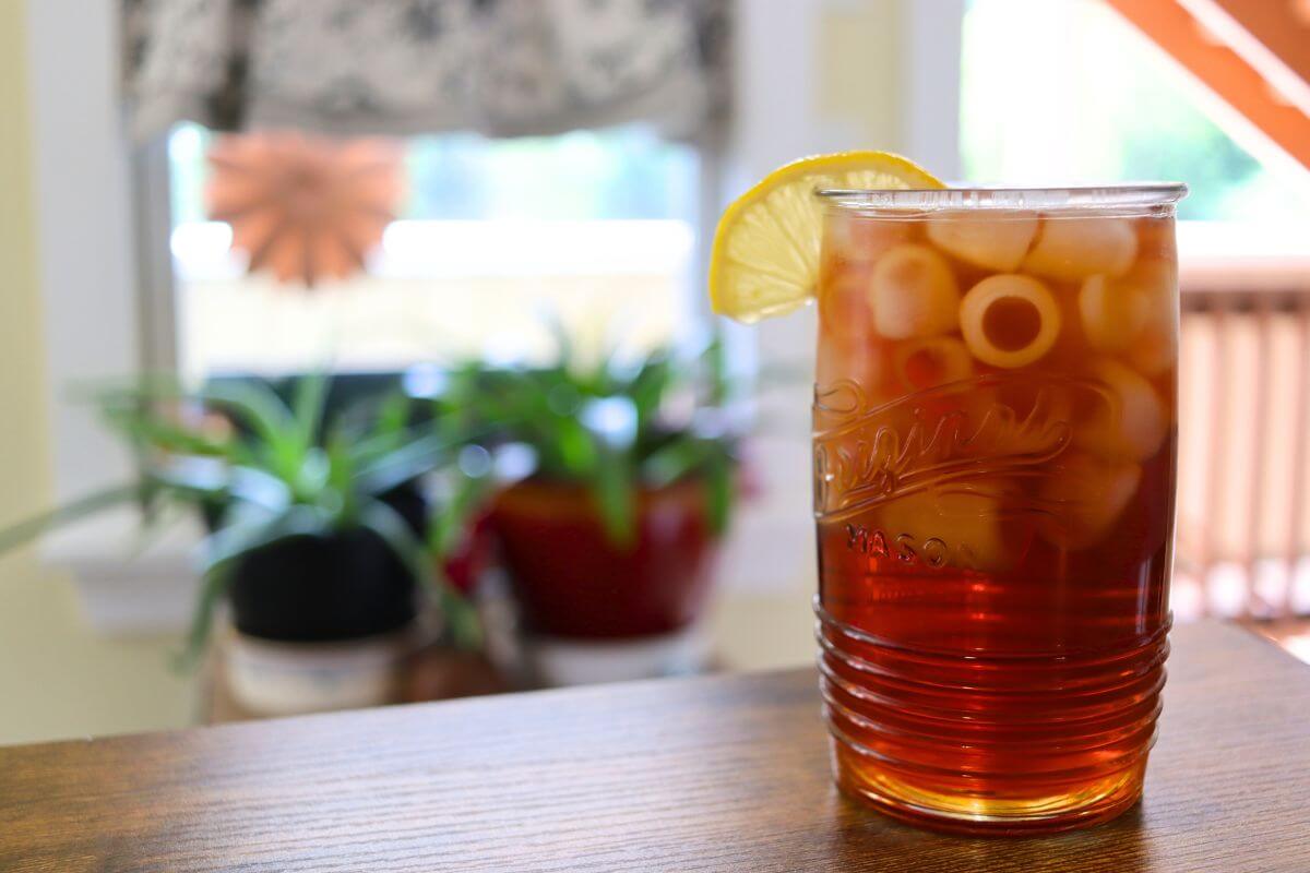 Iced tea in a glass with ice and a lemon slice.