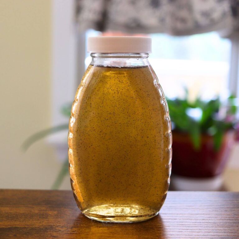 Homemade vanilla simple syrup with vanilla bean specks stored in a glass bottle.