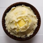 Creamy mashed potatoes from scratch topped with melted butter and freshly ground black pepper.