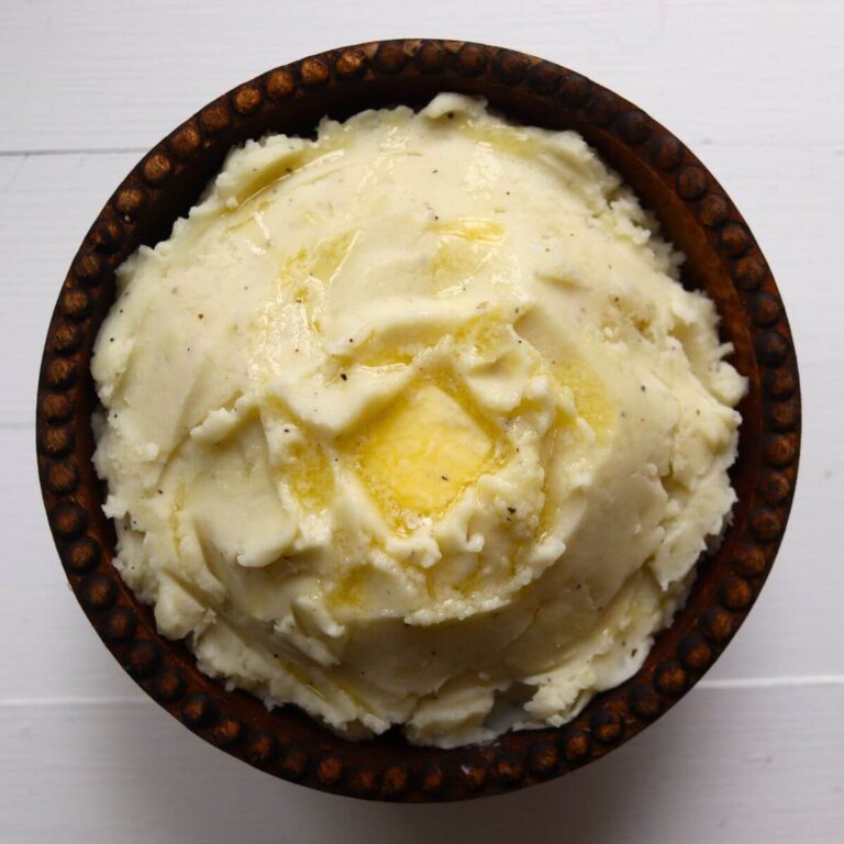 Creamy mashed potatoes from scratch topped with melted butter and freshly ground black pepper.