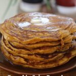 Pumpkin spice pancakes stacked on a brown plate with butter and maple syrup. Text overlay reads, "Pumpkin Spice Pancakes (from scratch)".