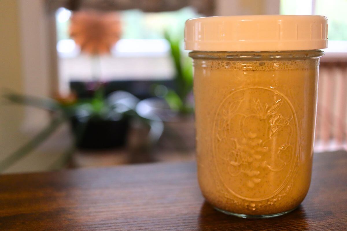 Glass jar filled with homemade cinnamon roll coffee creamer.