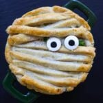 Halloween chicken pot pie topped with mummy-style pie crust strips and candy eyes.