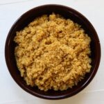 Homemade brown sugar with a soft, moist texture in a dark brown bowl.