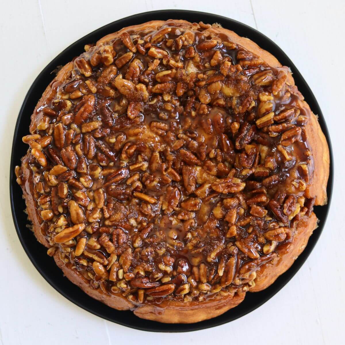 Pecan rolls topped with sticky maple brown sugar glaze and chopped pecans.
