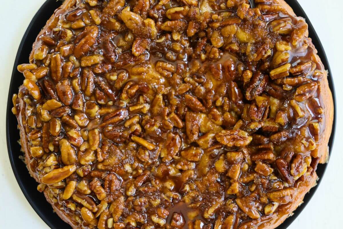 Pecan rolls covered with a gooey maple pecan topping after baking.