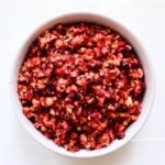 Cranberry orange relish with finely chopped cranberries and pecans in a white serving bowl.