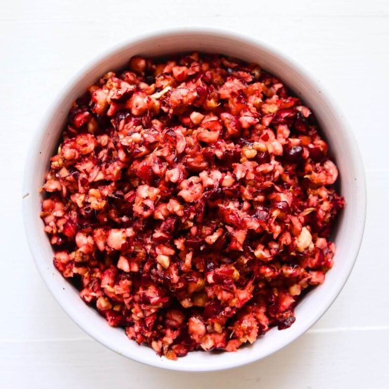 Cranberry orange relish with finely chopped cranberries and pecans in a white serving bowl.