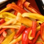 Sliced red, yellow, and orange bell peppers with the text “How to Freeze Bell Peppers.”