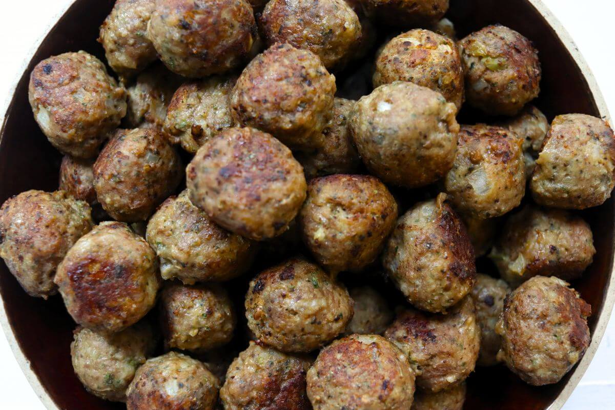 Golden-brown mini turkey meatballs with crisp, seared edges filling a bowl.