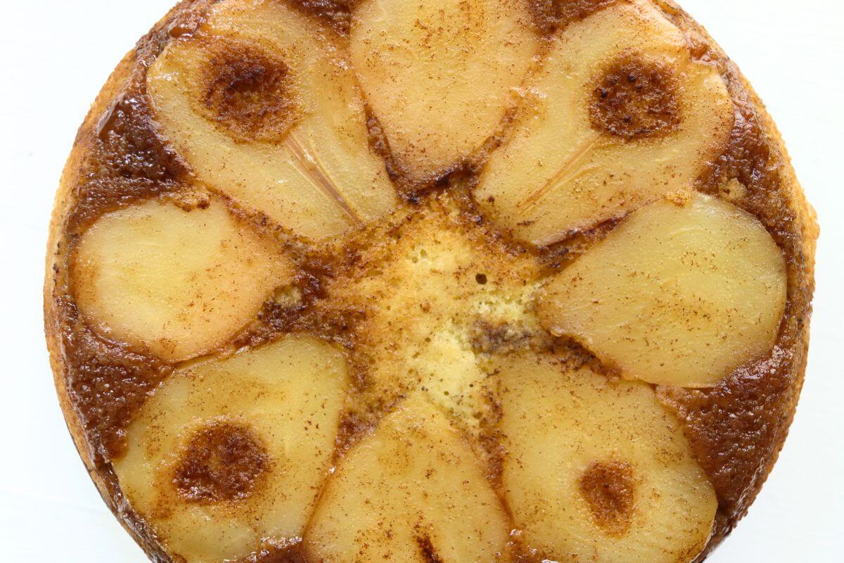 Pear upside down cake featuring tender pear slices arranged in a decorative pattern with a rich, buttery caramelized topping.