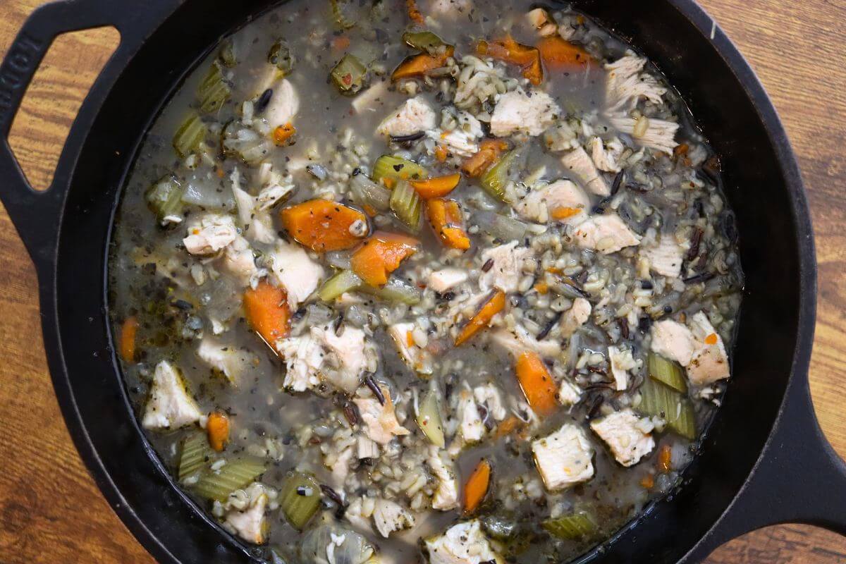 Homemade turkey rice soup with wild rice, diced carrots, celery, and pieces of roasted turkey in a savory broth.
