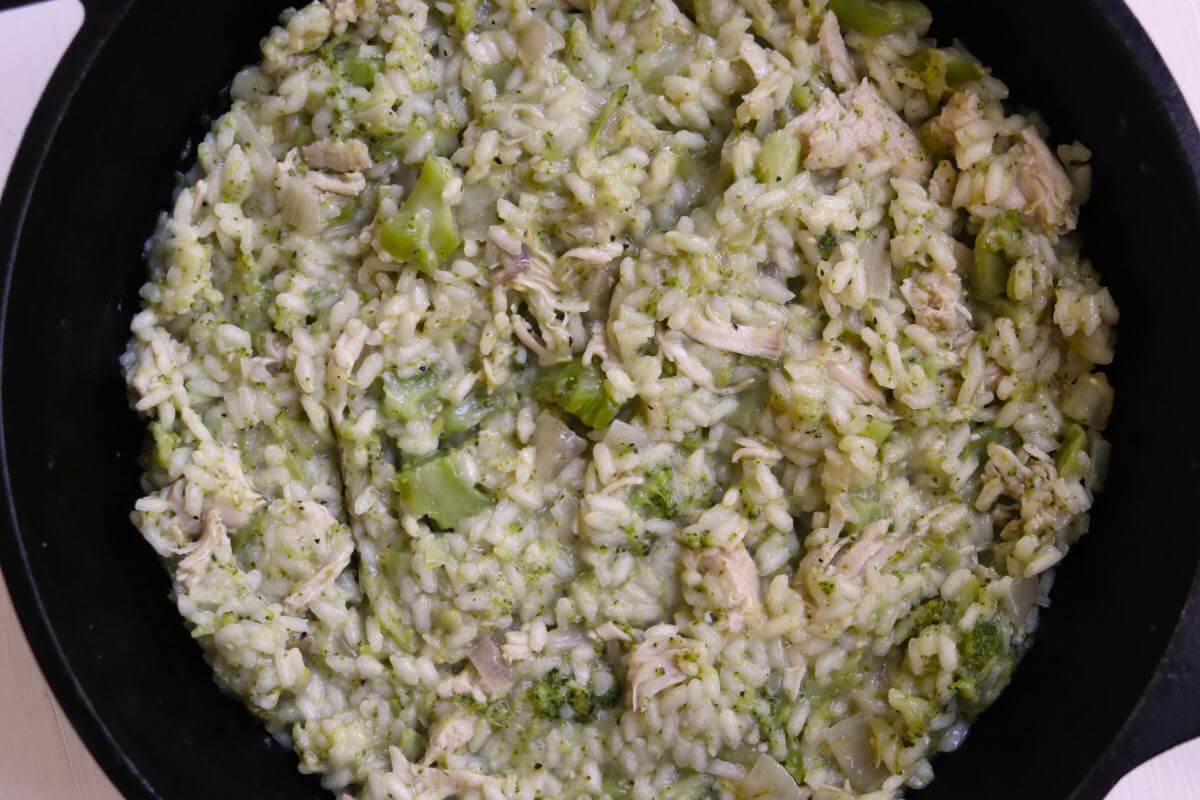 Turkey risotto with tender broccoli and shredded turkey in a creamy Parmesan rice mixture, served in a cast iron skillet.