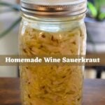 Wine sauerkraut packed in a mason jar with visible caraway seeds and a metal fermentation lid, featuring the text overlay “Homemade Wine Sauerkraut".